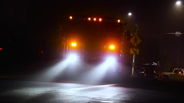 A firetruck turning on its lights on a dark foggy morning in California