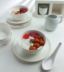 serving of two bowls of sweet porridge and starch balls with brown sugar sauce and coconut milk