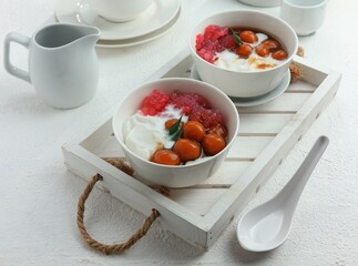 two bowls of sweet porridge and starch balls with brown sugar sauce and coconut milk