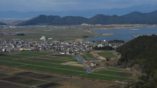 西の湖と安土城址を背景に走る223系新快速列車