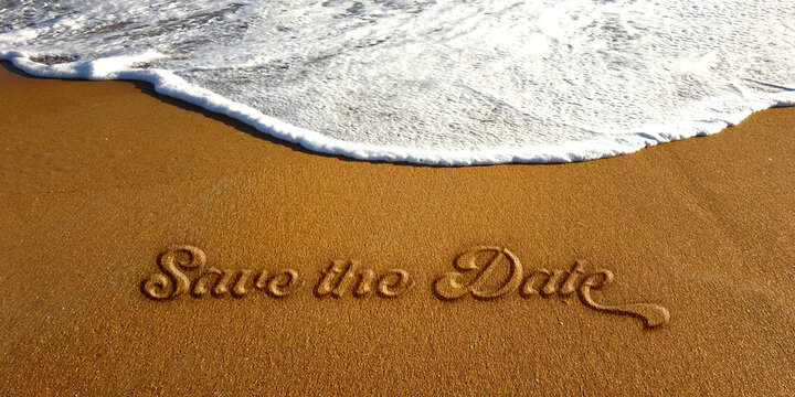 Save the Date text sign embossed lettering on the sand beach with white ocean wave. photo image
