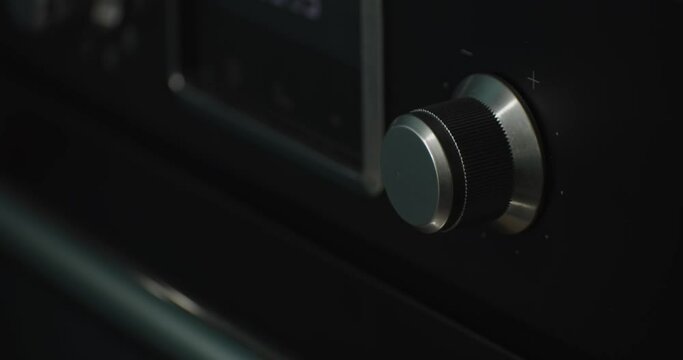 Man turning up the volume on a hifi stereo amplifier,  close-up shot.