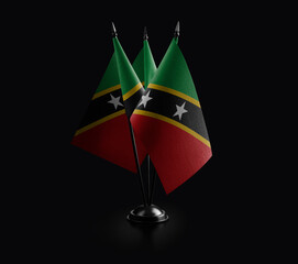 Small national flags of the Saint Kitts and Nevis on a black background