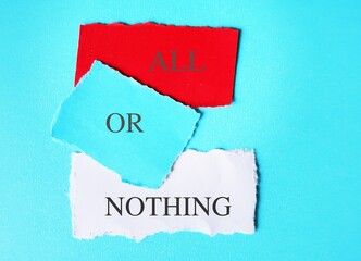 Torn note paper on blue background with text written ALL OR NOTHING means doing something either...