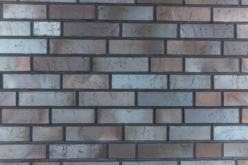 Wall made of baked decorative bricks. Construction and repair. Front view. Background. Space for text.