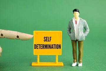 little people and plastic boards with the word self-determination. the concept of self-motivation....
