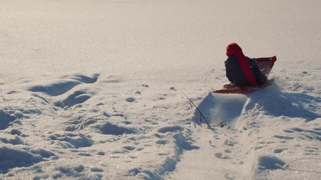 A little boy plays sleigh on a Christmas day in winter in Norway