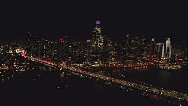 Circling aerial shot of Downtown San Francisco skyscrapers from Bay bridge at night