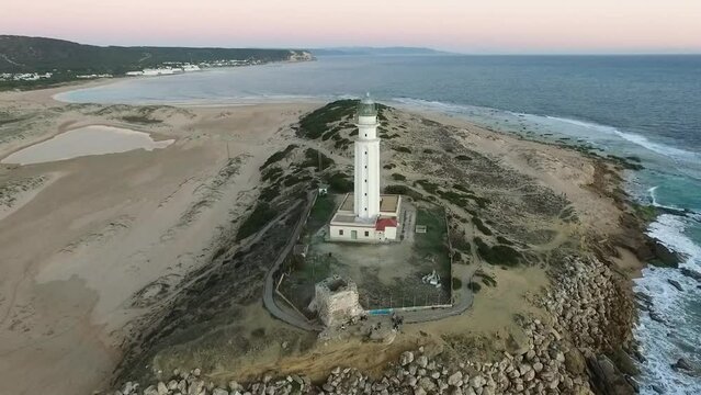 Drone revealing the light house and the surrounding parts of the beach on the shores of the Cadiz in Spain