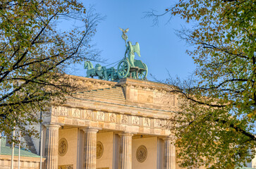The backside of the famous Brandenburg Gate in Berlin seen through some trees © elxeneize