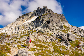 Adventurous athletic female hiker, hiking up a rugged mountain in the Pacific Northwest.
