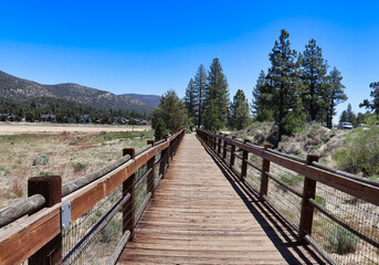 The elevated wooden bridge and the road next to it at the Dry Stanfield Marsh Wildlife and Waterfowl Preserve in Big Bear Lake, California