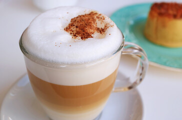 Closeup of Fluffy Froth of Cappuccino Coffee Sprinkled with Cocoa Powder 
