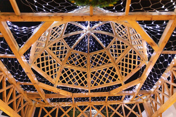 Wooden frame in the gazebo illuminated at night. Background