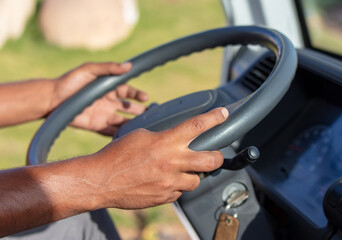 Man's hands on the steering wheel of a car.