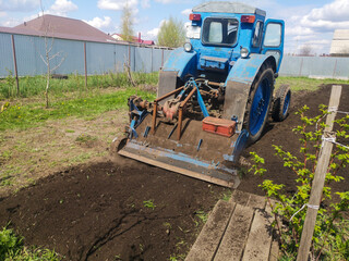 The tractor plows the soil on the field