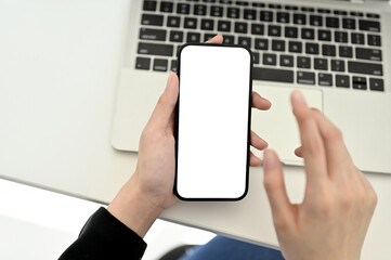 Top view of a businesswoman using her smartphone at her modern office desk.