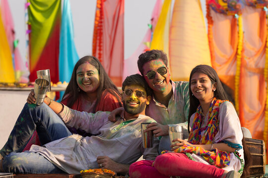 a group of friends sitting  while drinking bhang on holi