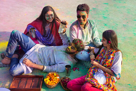 a group of friends sitting  while drinking bhang on holi