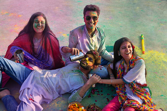 a group of friends sitting  while drinking bhang on holi