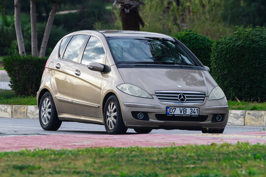 Side , Turkey -  January  29, 2023:   beige  Mercedes  B-class   is driving fast on the street on a warm summer day against the backdrop of a  palms