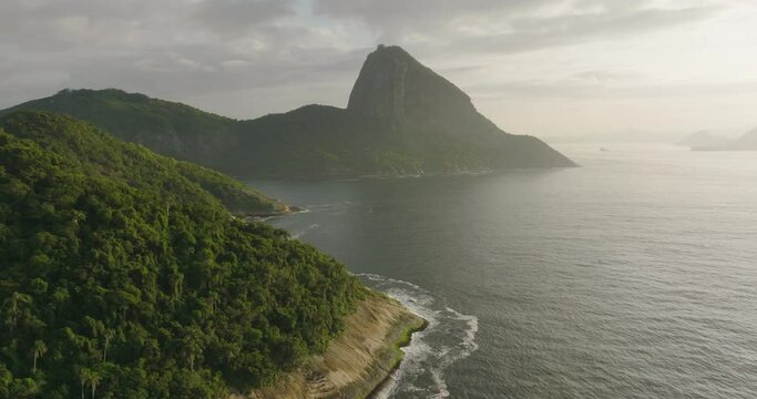 Aerial Scenic View Of Sugarloaf Mountain Under Clouds, Drone Flying Backwards Over Guanabara Bay - Rio de Janeiro, Brazil