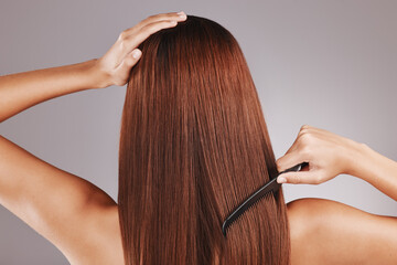Beauty, comb and woman doing haircare in a studio with a brazilian, keratin or botox treatment. Health, hygiene and back of female model with a long, healthy and shiny hair style by a gray background - obrazy, fototapety, plakaty