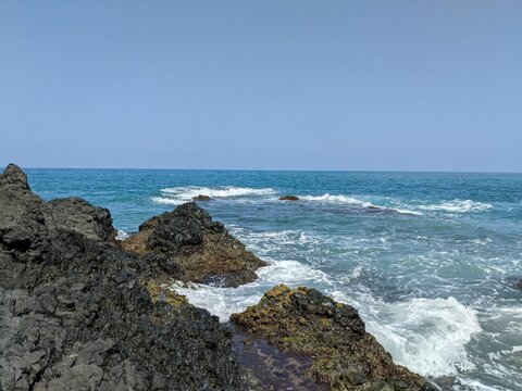 waves crashing on rocks with the sean in the backgroun in veracruz, mexico, landcape, holidays in latinoamerica, kelp in the cliffs