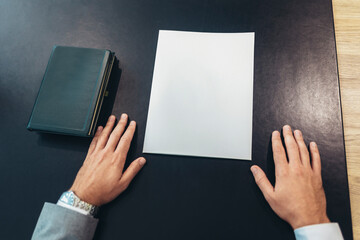 Business man hold empty paper on desk