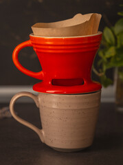 Brewing coffee in a funnel. The process of making branded coffee in a funnel on a gray wooden...