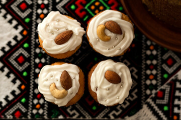 Easter portions of homemade cupcakes on an embroidered towel. Flat lay