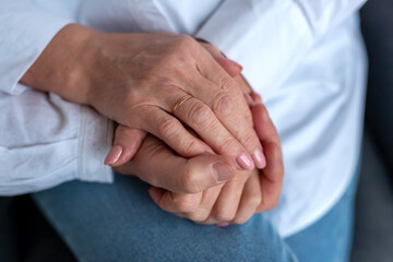 Hands of an aged couple holding each other, togetherness and happiness
