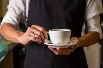 a bartender in a black apron with a cup in his hands. template for design