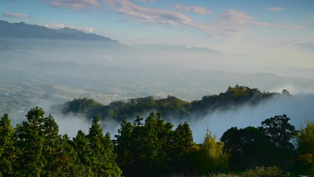 The valleys and mountains are shrouded in mist. Lush hilltops. Looking far away from the top of the mountain. Dahu Township, Miaoli County, Taiwan