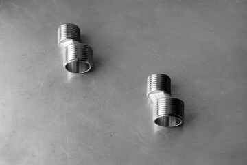 Threaded fitting. Steel eccentrics on the gray metal surface.