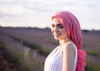 woman with pink cancer scarf in a lavender field