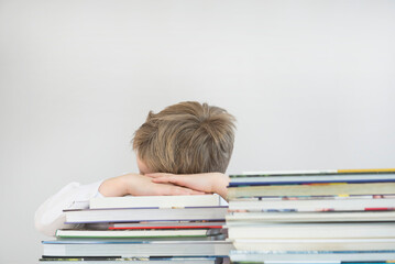 Boy sleeping on stack of books, close up