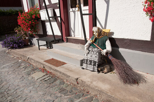 Typical harzer witch doll in front of old timber framed buildings, Germany