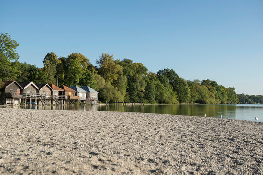 Lake shore boathouse autumn trees pebble beach