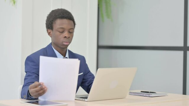 African Businessman Working on Laptop and Documents