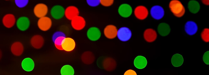 Round, bright, blurry garland lights. Abstract illustration of colorful bokeh lights on a dark background.