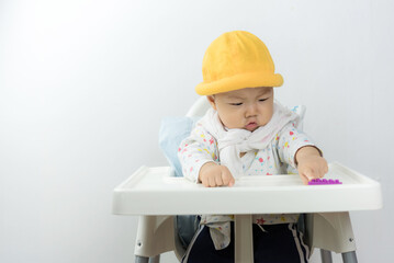 asian baby sitting in high chair white background,baby in home,thailand baby