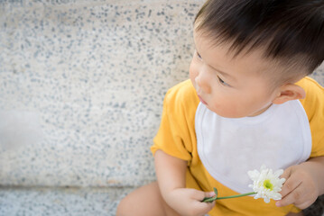 Fototapeta premium Asia cute baby boy holding white flower
