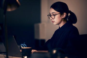 Woman, night office and laptop for business, coding and strategy in dark startup company. Female working overtime online with technology on website, computer programmer and search internet analytics