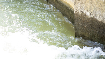 artificial shore with foaming clear water. horizontal photo of urban reservoir