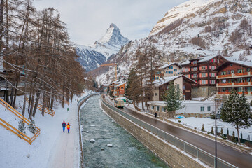 Naklejka premium Beautiful view of Matterhorn from winter Zermatt. River and wooden houses in the mountains