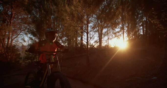 Low Angle Shot Of A Mountain Biker Working Hard At Pushing His Bike Over Extremely Rough Terrain