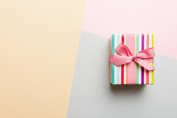 holiday paper present tied pink ribbon bow top view with copy space. Flat lay holiday background. Birthday or christmas present. Christmas gift box concept with copy space