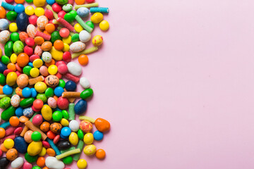 Obraz premium Mixed collection of colorful candy, on colored background. Flat lay, top view. frame of colorful chocolate coated candy