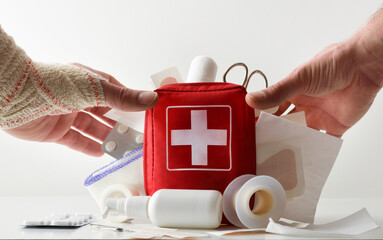 First aid kit concept with hands picking up bag full